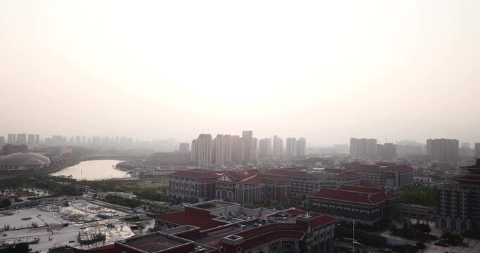 Flying Over China Modern City During Sunset .  Aerial View Of A Xiamen, Jimei District.