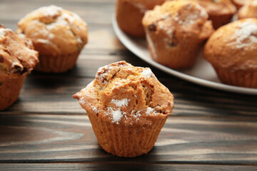 Vanilla muffins. Sweet cupcakes on brown background.