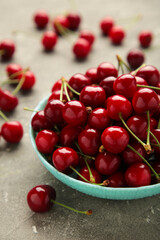 Fresh sweet cherries bowl on grey background, top view