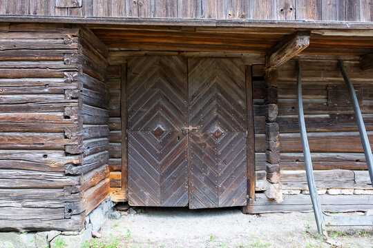 Wooden vintage log barn big gate close-up.