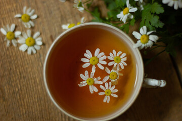 Cup of medicinal chamomile tea on a wooden table