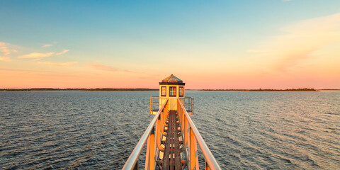 Sunset over Dutch national park Lauwersmeer in Friesland with an ancient lighthouse in front - obrazy, fototapety, plakaty