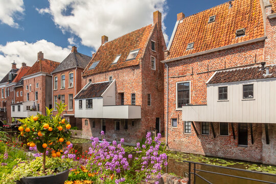 Summer view of Dutch medieval houses with hanging kitches at the Damsterdiep canal in Appingedam, Groningen, The Netherlands