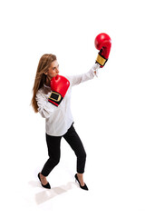 Full-length portrait of young woman, employee in office cloth and boxing gloves isolated over white studio background. Showing professional ambitions