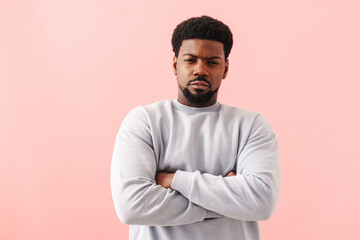 Black displeased man posing with arms crossed at camera