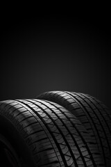 New tires on black background with copy space. Vertical image.
