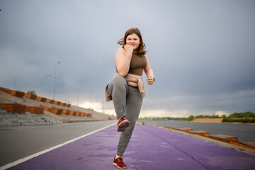 European teenage girl overweight on jog on treadmill along embankment of city, overweight and...