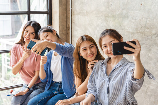 Happy Asian female friends teenage girls taking selfie at home, enjoing their time together, having fun.