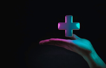 Obraz premium Hand hold ing Plus sign on dark technology background for positive thinking mindset of personal development benefit and health insurance concept.