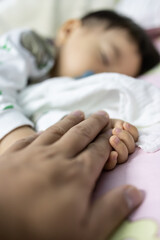 Portrait image of​ 1-2 years old​ holding father hand during baby sleeping