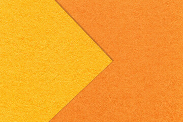 Fototapeta premium Texture of light yellow and orange paper background, half two colors with arrow, macro. Structure of red craft cardboard