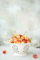 large pink cherries in a white colander