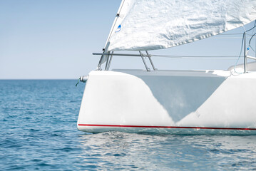 Stern with a sail of a white sport keelboat yacht