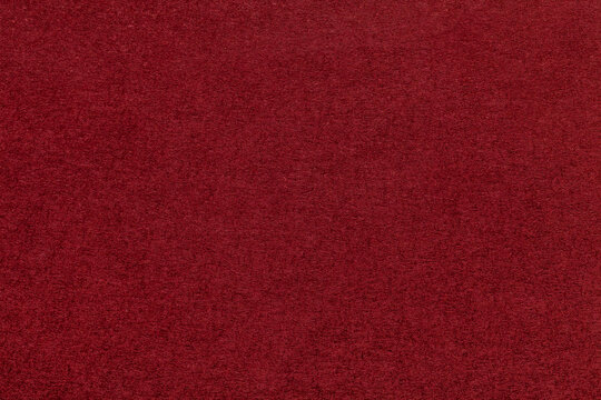 Texture of dark red and wine colors paper background, macro. Structure of dense maroon craft cardboard.