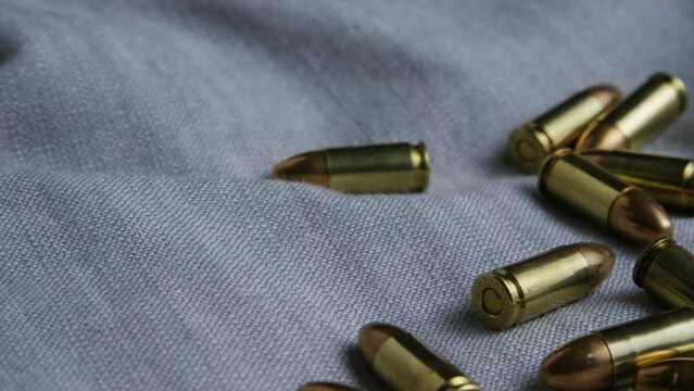 9mm pistol bullets resting on a cloth and camera spinning around.