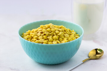 Breakfast cereal close-up. Bowl of corn flakes on a white marble table