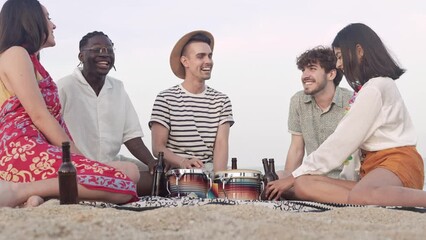 Celebration on the beach. Cheerful friends together enjoying summer near the sea, toasting beer to celebrate friendship