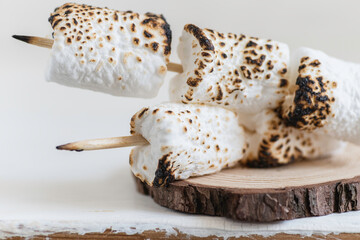 Roasted marshmallow on wooden background.