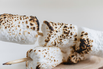 Roasted marshmallow on wooden background.