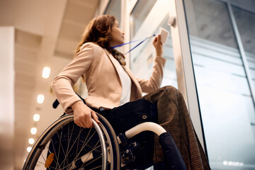 Close up of businesswoman with disability using ID card to enter in the office. - Powered by Adobe