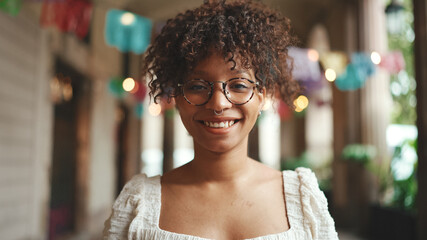 Closeup portrait of a young woman in glasses smiling posing on smartphone selfie camera. Positive...