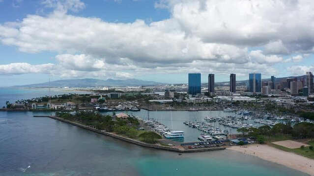 Descending panning aerial shot of a boat marina in downtown Honolulu, Hawaii. 4K