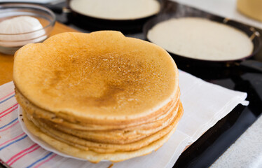stack of appetizing flour pancakes in the kitchen during cooking