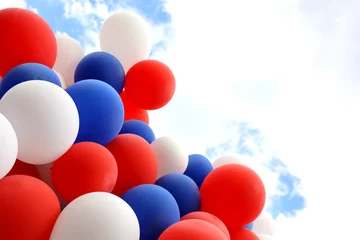 Abwaschbare Fototapete Helium balloons fly on background of sky with clouds. Red, blue and white colors for festive background © Oleg
