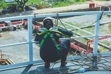 Male worker wearing safety first harness and safety lone working at high handrail