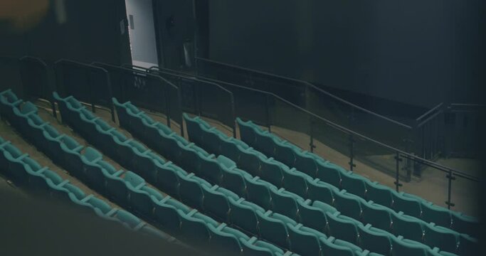 Panning shot of rows of empty movie theater seats in cinema auditorium