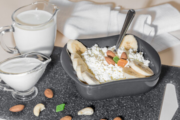 Sour-milk cottage cheese with banana. A healthy breakfast of fruits, candied fruits, nuts and dairy products. Healthy food concept
