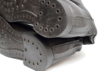 Back view of old military boots made of leather on white background, black army boots isolated on white, combat and ceremonial shoes of a soldier of the army of the Soviet Union
