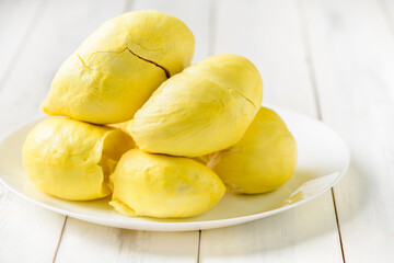 Fresh durian (monthong) on white dish and white wood background, king of fruit from Thailand