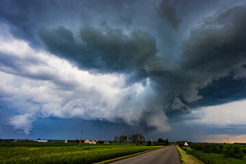 Naklejka na ściany i meble Storm clouds over field, tornadic supercell, extreme weather, dangerous storm