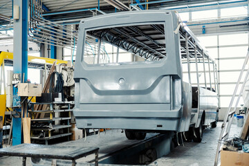 An industry worker checking on bus construction in vehicle production factory.