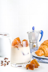 Cold coffee cocktail with frozen coffee espresso ice cubes and milk. Summer cool refreshment latte drink on white background copy space