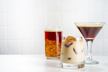 Set of three coffee drinks in various cocktails glasses, on white background copy space