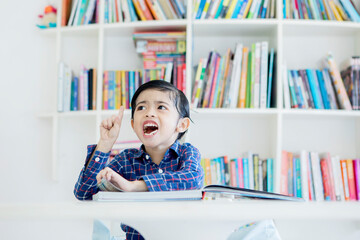 Cute little boy getting an idea in library