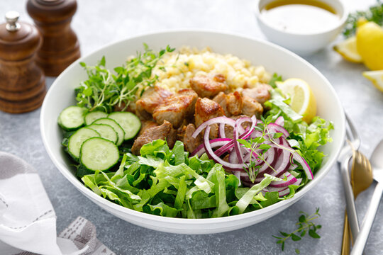 Pork kebab bulgur salad bowl with cucumber, lettuce, thyme and mustard sauce
