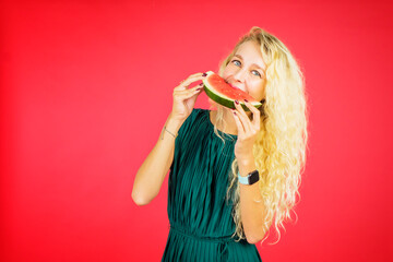 Blonde woman eating watermelon on studio
