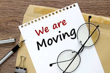 we're moved. . text on white paper next to craft envelope