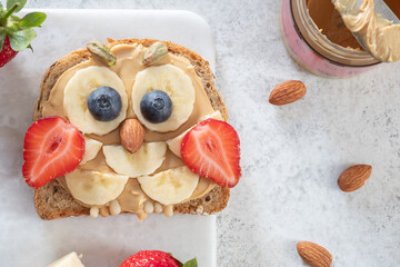 Kids breakfast or lunch or snack toast with peanut butter spread, banana, strawberry and blueberry...