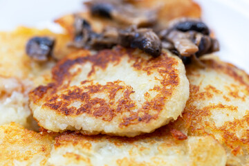 Freshly fried potato fritters with a roast of mushrooms