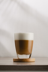 Cappuccino in a glass cup on a wooden table, Coffee and froth milk.