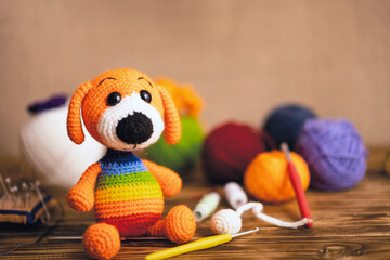 Crochet from the yarn with amigurumi dolls. Background photo. Soft toy, knitting hook, balls of yarn.