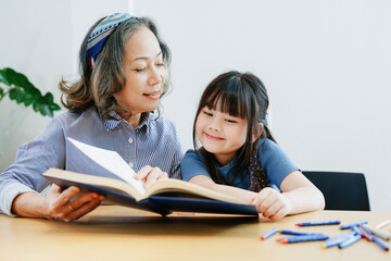 Fototapeta premium Asian portrait, grandchild granddaughter grandma grandmother and granddaughter happily join in activities to enhance skills for grandchildren
