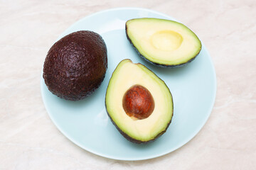 Top view of fresh avocado and cut in half on a plate. Healthy foods. Flat lay.