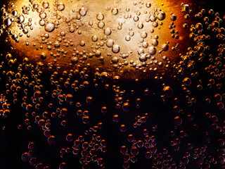 macro photo of the texture of bubbles in a glass of refreshing cold cola with ice