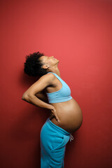 Pregnancy painful sciatica. Sporty pregnant black woman suffering low back pain.