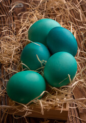 Colorful easter eggs on hay. Bright and colorful eggs on wooden background